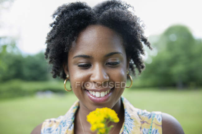 Porträt einer jungen Frau mit gelben Blumen. — Stockfoto