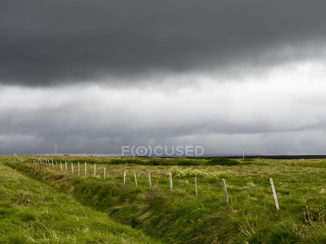 Темні хмари дощу над зеленими сільськогосподарськими угіддями . — стокове фото