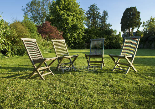 Cadeiras de jardim colocadas no gramado verde em Gloucestershire no verão . — Fotografia de Stock