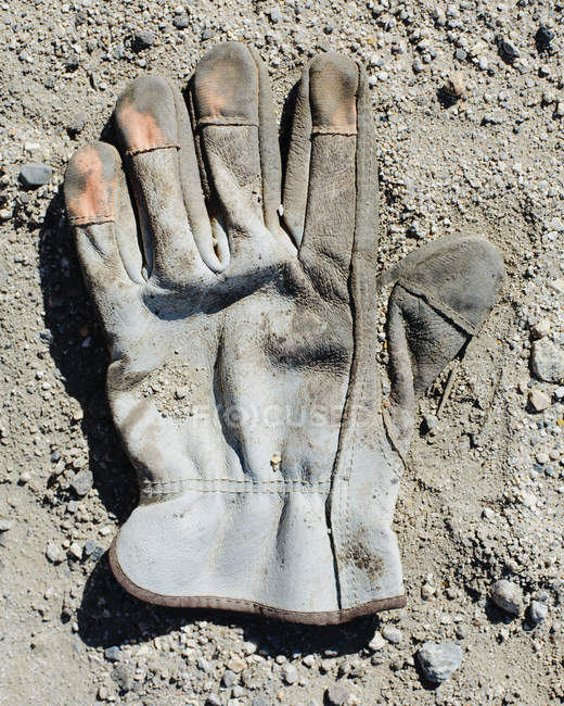 Used protective glove on oil field ground. — Stock Photo