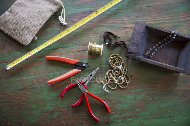Plateau à bijoux avec pinces, fil, plateau en bois et ruban à mesurer . — Photo de stock