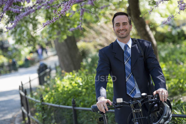 Чоловік у діловому костюмі Астрід велосипед з шоломом у місті . — стокове фото