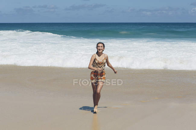 Happy teenage girl running on sea beach. — Stock Photo