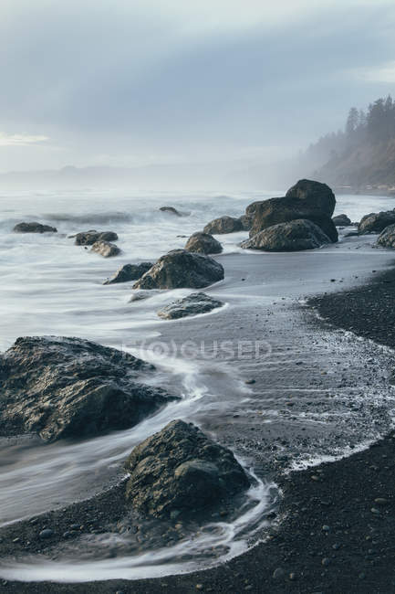 Rock formation on coastline with sandy beach at low tide, Olympic National Park, USA — Stock Photo