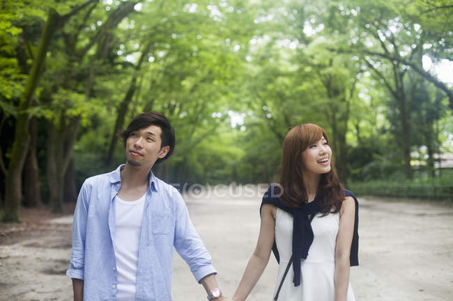 Young couple holding hands on date in park. — Stock Photo