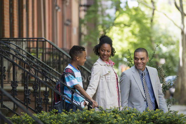 Two parents and elementary age boy walking together on street staircase. — Stock Photo