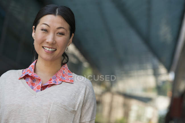 Portrait of Asian woman in pink shirt and beige sweater. — Stock Photo