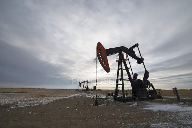 Oil pumpjack at drilling site on oil field in Saskatchewan, Canada. — Stock Photo