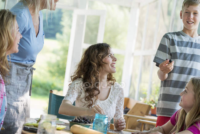 Family cooking at cooking at table on farmhouse terrace. — Stock Photo