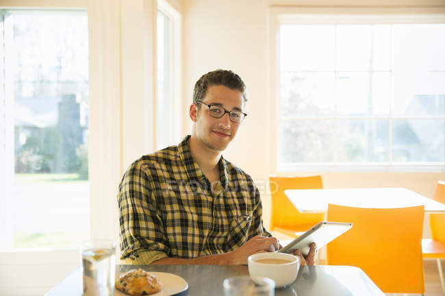 Молодой человек в кофейне с помощью цифрового планшета . — стоковое фото