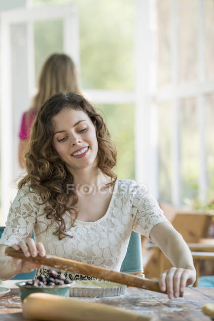 Young woman cooking at cooking at table on farmhouse terrace. — Stock Photo