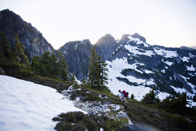 Young man hiking on snow patch in mountains of Cascades in Washington, USA. — Stock Photo