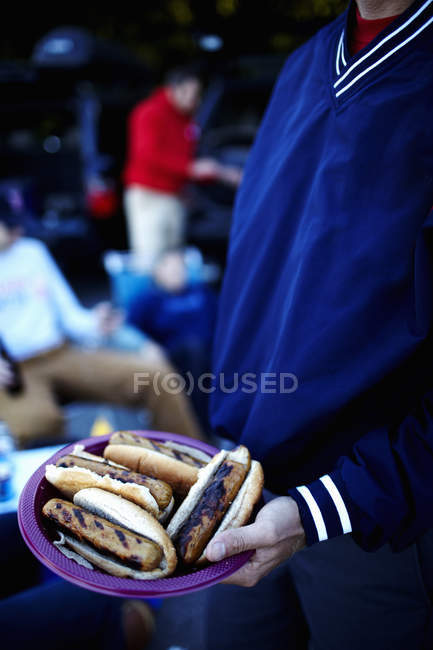 Freundeskreis bei Grillparty mit Hotdogs. — Stockfoto