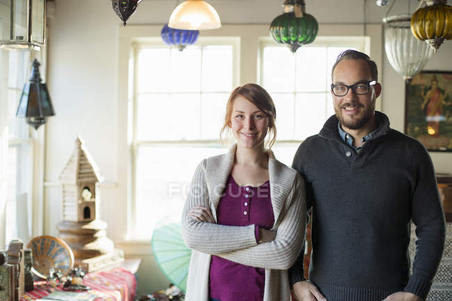 Couple of owners standing in store full of antique goods. — Stock Photo