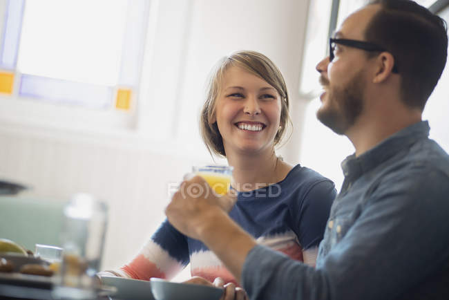 Couple sitting in coffee shop smiling and talking. — Stock Photo