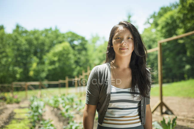 Young woman standing at traditional farm in countryside — Stock Photo