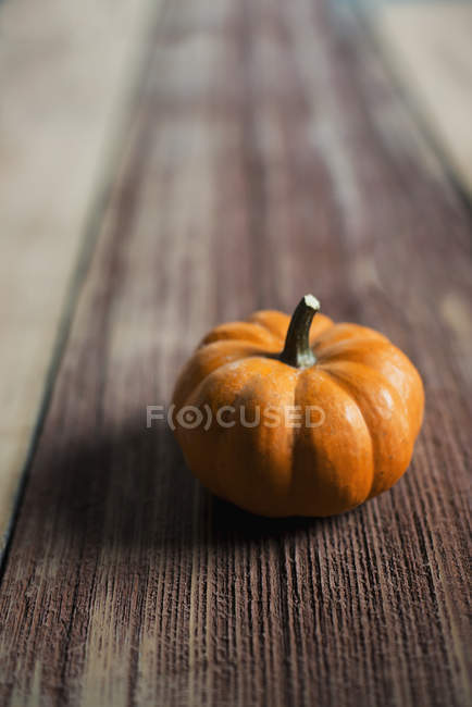 Small round pumpkin on wooden tabletop. — Stock Photo