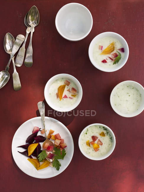 Mesa colocada com tigelas brancas redondas de alimentos frescos no fundo vermelho . — Fotografia de Stock