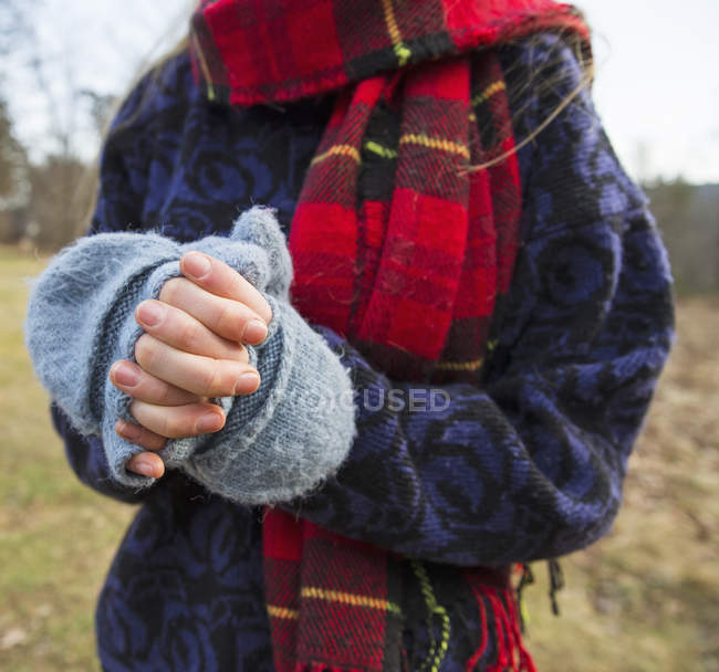 Обрізаний вид жінки з тартановим шарфом зігріваючими руками в холодну погоду . — стокове фото