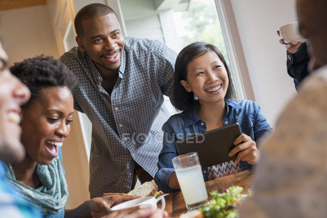 Gruppe von Menschen beim Mittagessen und der Nutzung digitaler Tablets bei einem Treffen im Café. — Stockfoto