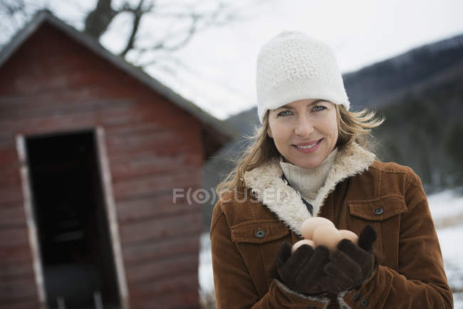 Woman holding clutch of hen eggs in hands. — Stock Photo