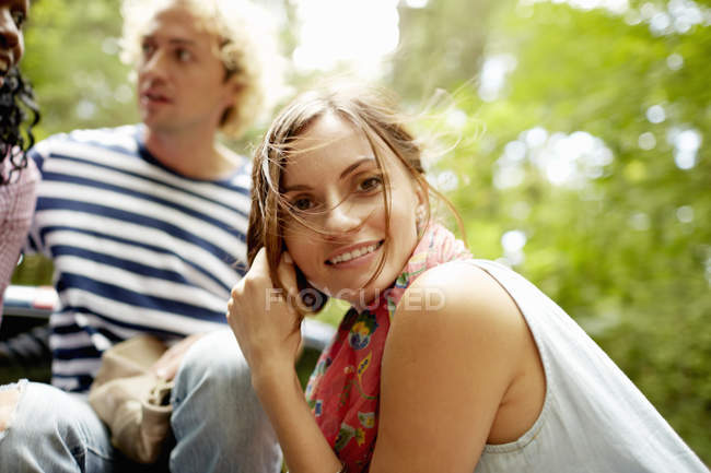 Молодой человек и женщины, сидящие на природе в лесу
. — стоковое фото