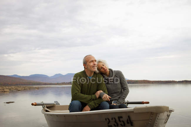 Ältere Männer und Frauen sitzen im Ruderboot auf dem Wasser des Herbstsees. — Stockfoto