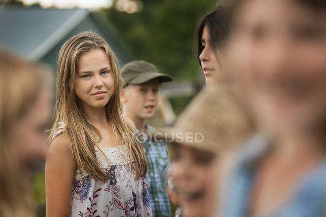 Gruppo di adolescenti e bambini in piedi di fronte all'agriturismo in campagna . — Foto stock