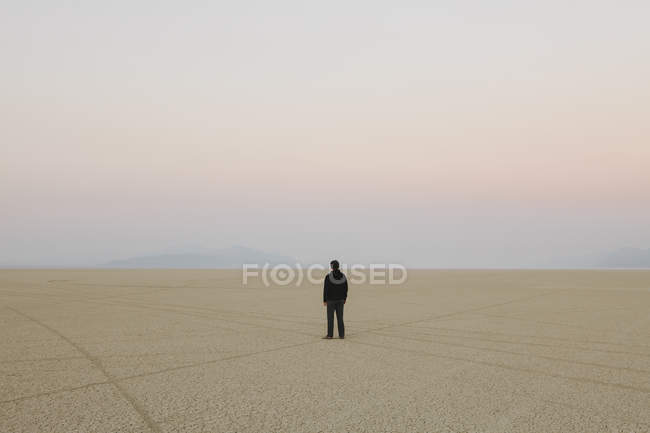 L'uomo in piedi nel vasto paesaggio desertico — Foto stock