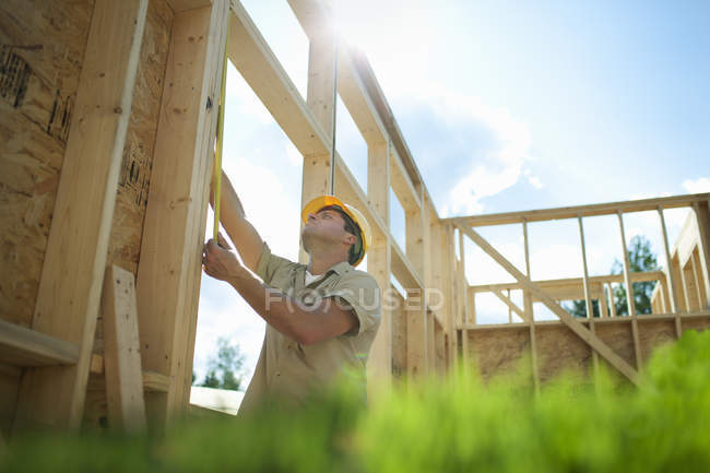 Bâtiment de travailleurs de la construction masculins sur maison domestique sur le chantier de construction dans la campagne — Photo de stock