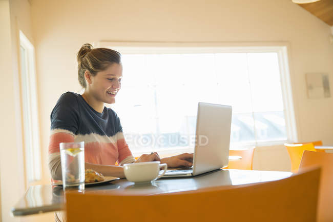 Junge Frau benutzt Laptop in Café. — Stockfoto
