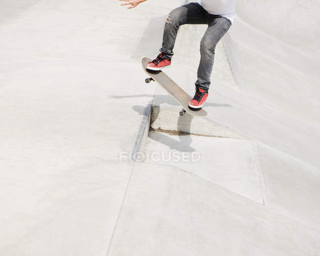 Обрезанный вид скейтбордиста, стоящего на борту в красных кроссовках . — стоковое фото
