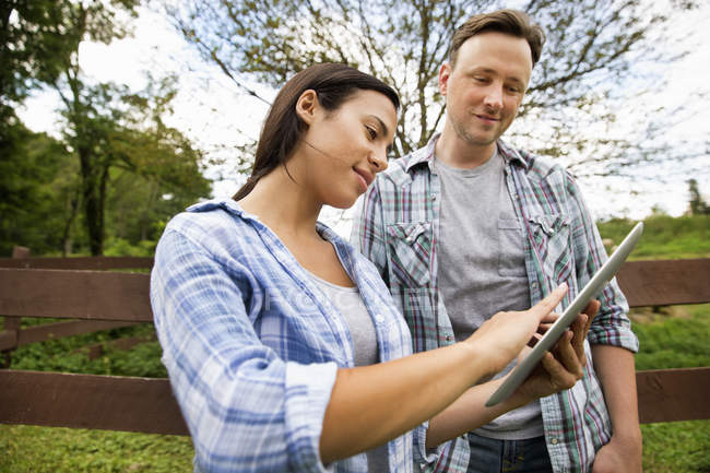 Чоловік і жінка використовують цифровий планшет на органічній фермі . — стокове фото