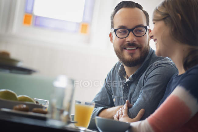 Couple sitting, smiling and talking in coffee shop. — Stock Photo