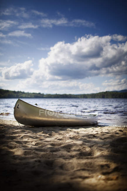 Barco de canoa encalhado na margem do lago na floresta com paisagem nebulosa cênica . — Fotografia de Stock