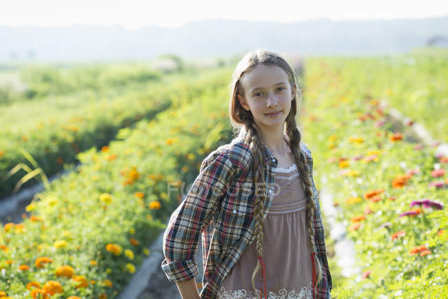 Допідліткова дівчина позує на квітковій фермі . — стокове фото