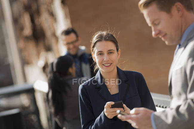 Frau steht mit Handy auf der Straße und Gruppe von Menschen in New York, USA. — Stockfoto