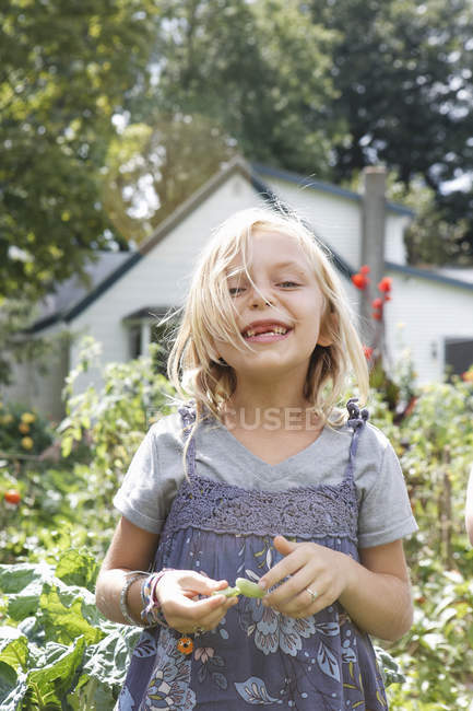 Blondes Mädchen im Nadelkleid mit grünen Bohnen auf dem Land. — Stockfoto