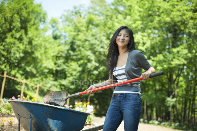 Young woman digging soil at traditional farm in countryside — Stock Photo