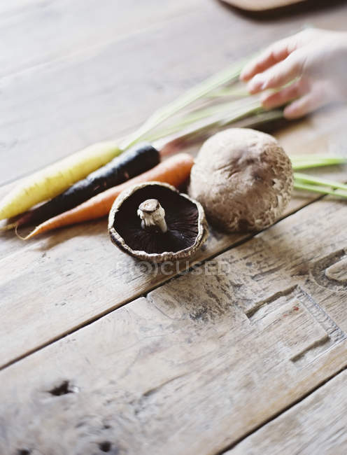 Букет з моркви і грибів на дерев'яні таблиці. — стокове фото