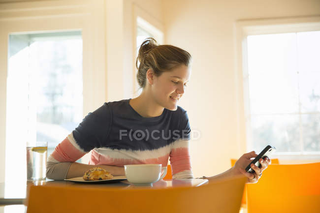 Jovem mulher usando smartphone no café . — Fotografia de Stock