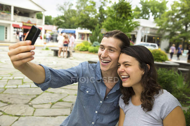 Young couple standing side by side and taking selfie on street. — Stock Photo