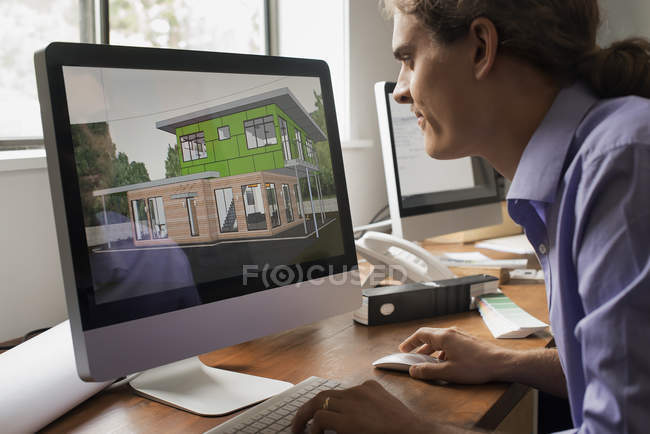 Architect working on green construction project at computer monitor in office. — Stock Photo