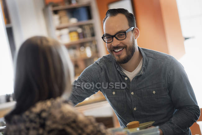 Casal sentado, sorrindo e falando no café . — Fotografia de Stock