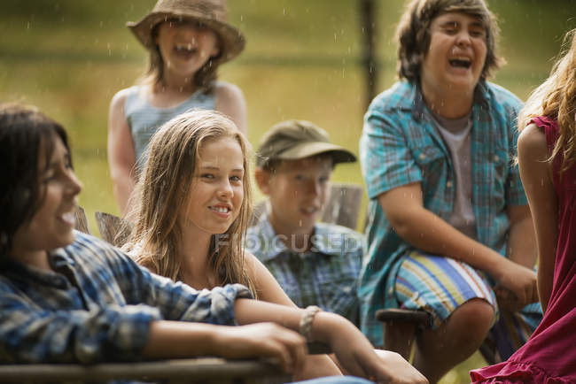Grupo de adolescentes y niños riendo en el campo . - foto de stock