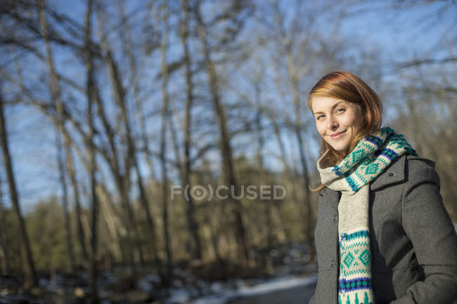 Jeune femme en foulard tricoté en forêt en hiver . — Photo de stock