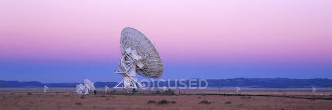 Grande telescópio de rádio em vale sob céu rosa ao pôr-do-sol, Novo México, EUA — Fotografia de Stock