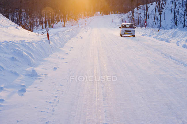 Carro na estrada coberta de neve de Hokkaido, Japão — Fotografia de Stock