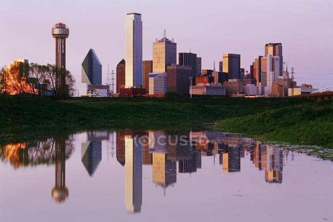 El horizonte de Dallas se refleja en el estanque al atardecer, Estados Unidos - foto de stock