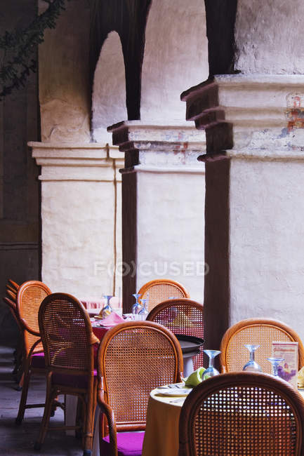 Sedie e tavoli da ristorante tra colonne a Oaxaca, Messico — Foto stock